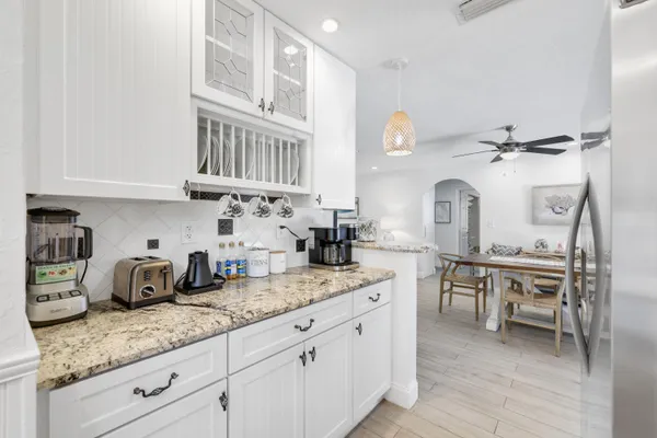 a kitchen with granite countertop a sink a stove and cabinets