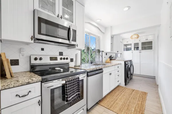 a kitchen with stainless steel appliances granite countertop a stove microwave and sink