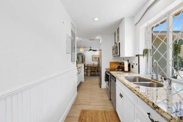 a kitchen with granite countertop a sink stove and refrigerator