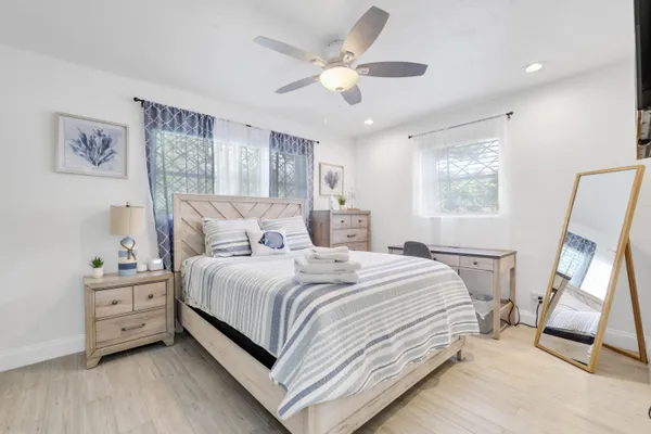 a bedroom with a bed and a large mirror on the dresser