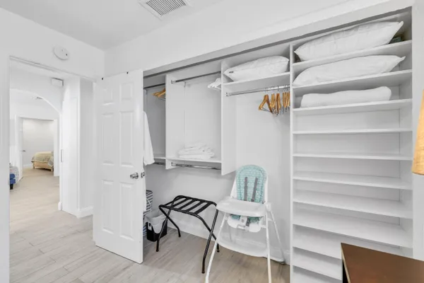 a view of walk in closet with empty racks