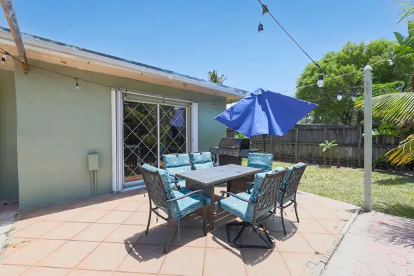 a view of a patio with a table and chairs under an umbrella