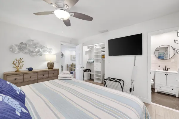 a spacious bedroom with a bed and a flat screen tv