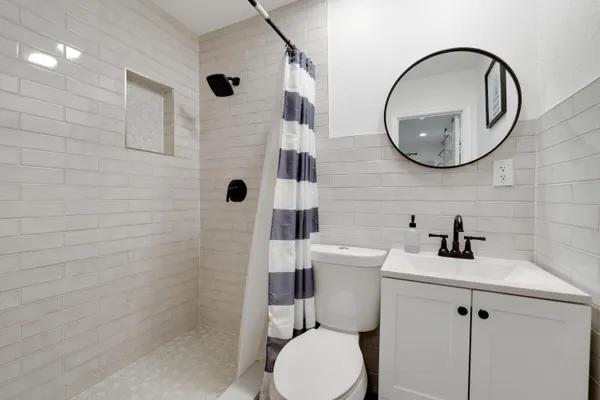 a bathroom with a toilet a sink and mirror