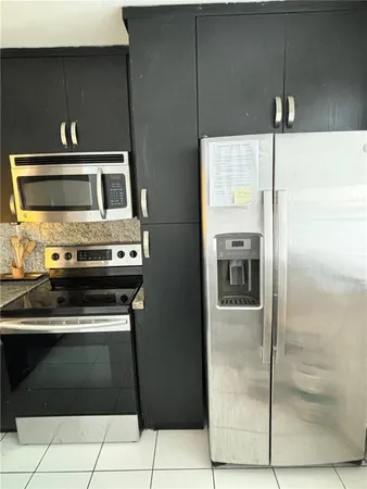 a kitchen with a refrigerator stove and cabinets