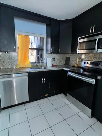 a kitchen with a sink stove top oven and cabinets