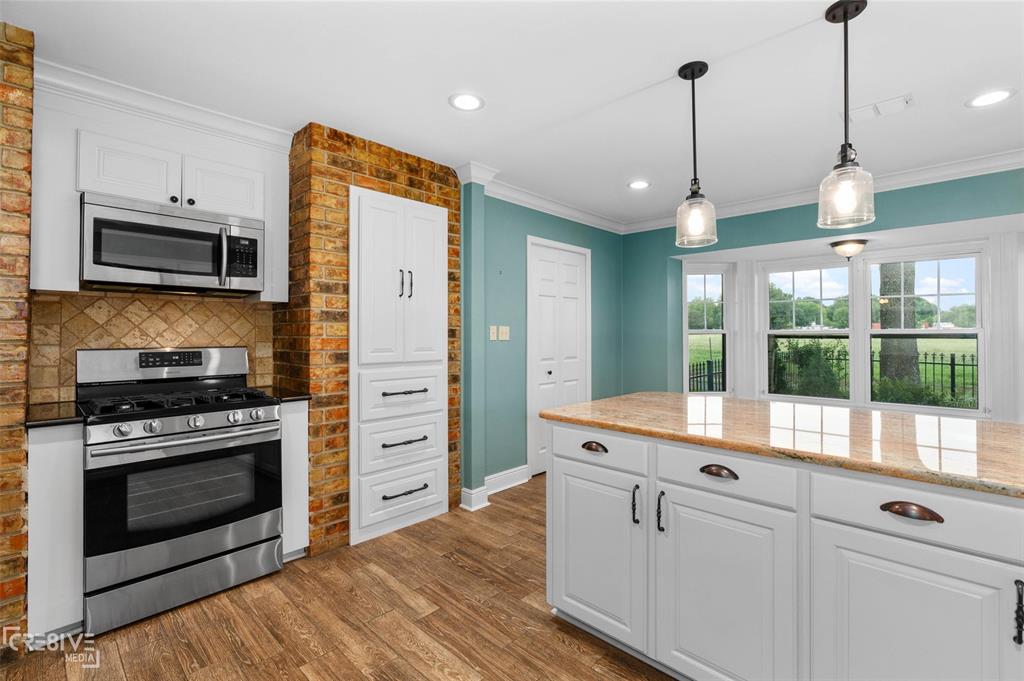 6095 Keithville-Springridge Road Keithville, LA 71047 - Photo 12 of 38 a kitchen with stainless steel appliances granite countertop a stove a sink and a wooden floor