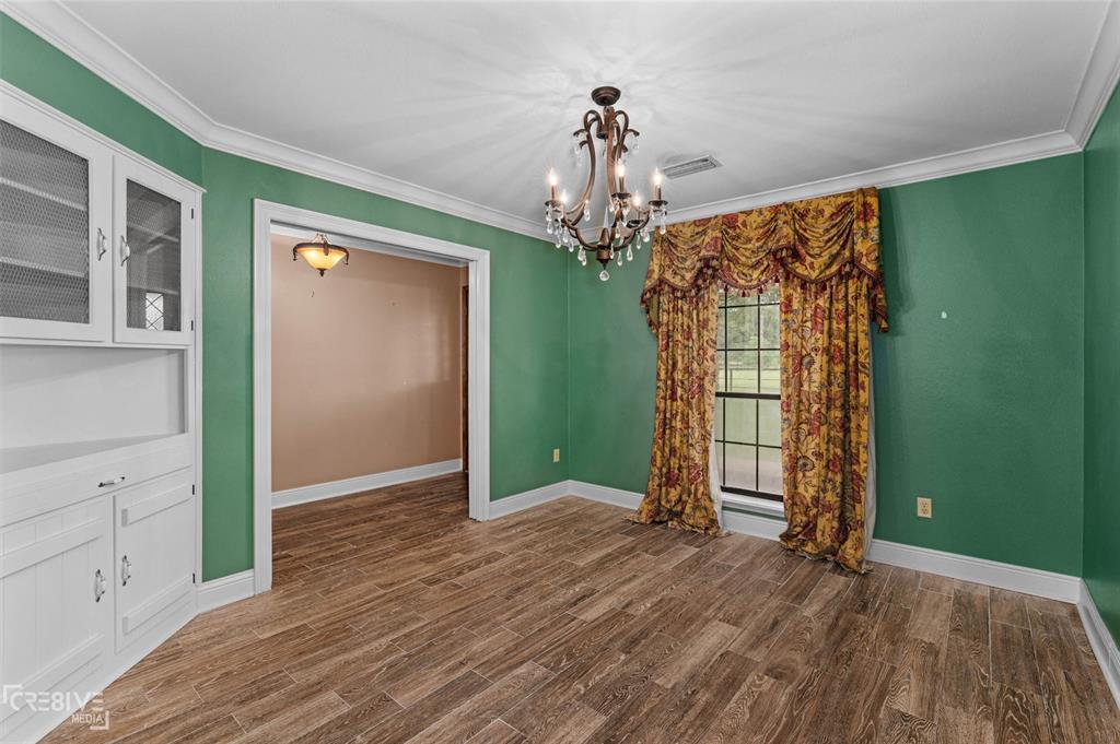 6095 Keithville-Springridge Road Keithville, LA 71047 - Photo 14 of 38 an empty room with wooden floor chandelier and windows