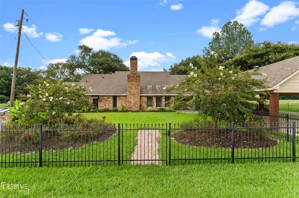 a view of a house with a big yard and a fountain
