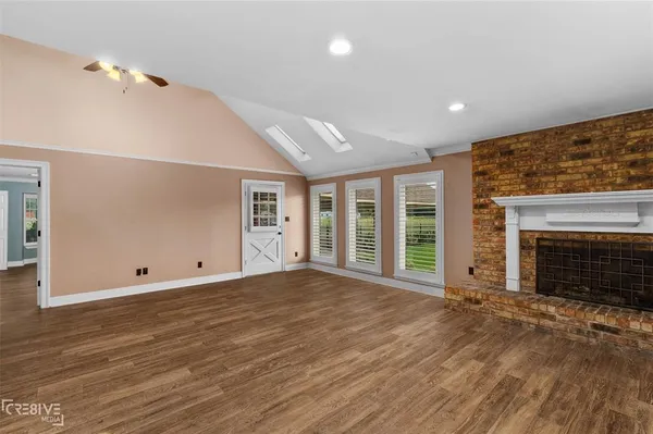 an empty room with floor to ceiling window and fireplace