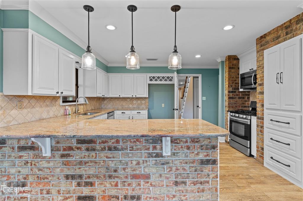 6095 Keithville-Springridge Road Keithville, LA 71047 - Photo 10 of 38 a large kitchen with stainless steel appliances kitchen island granite countertop a refrigerator a sink and a stove