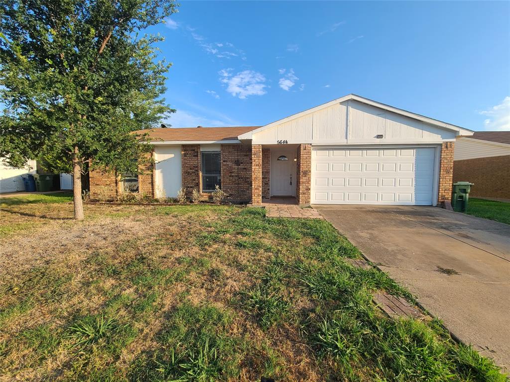 Ranch-style home with a garage and a front lawn