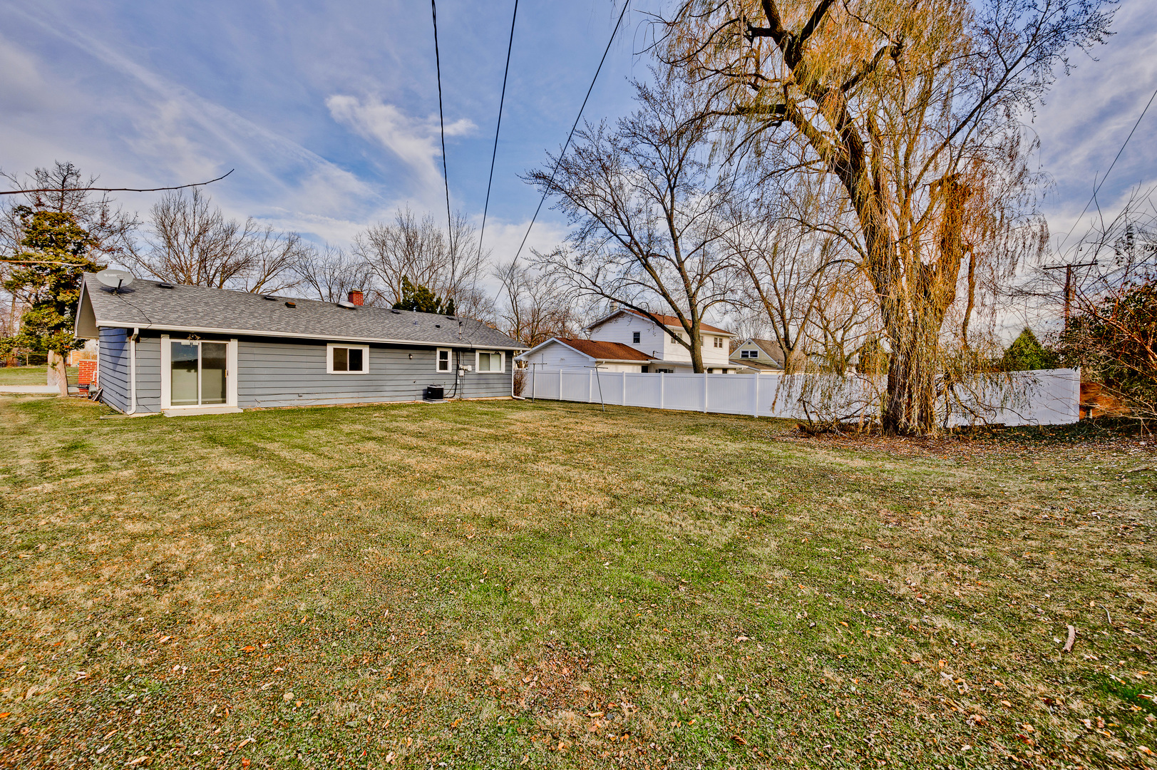 555 Jamison Lane Hoffman Estates, IL 60169 - Photo 16 of 16 a large white house with a large tree next to a yard