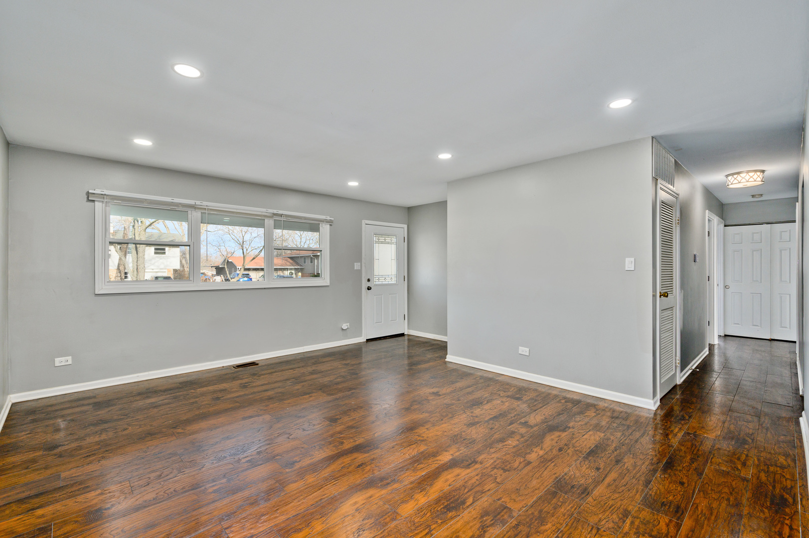 555 Jamison Lane Hoffman Estates, IL 60169 - Photo 2 of 16 an empty room with wooden floor and windows