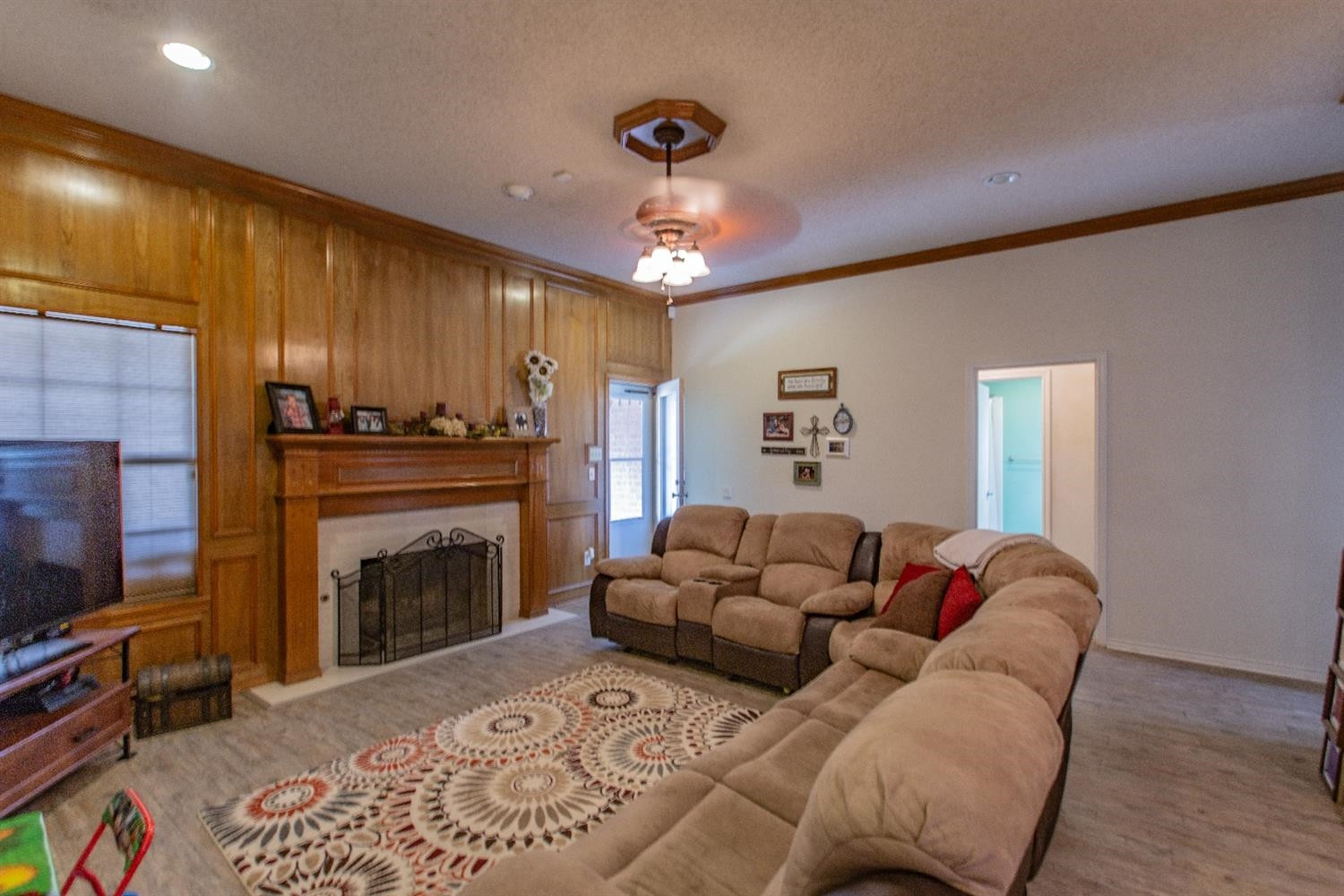 5738 94th Street Lubbock, TX 79424 - Photo 2 of 10 a living room with furniture a fireplace and a flat screen tv