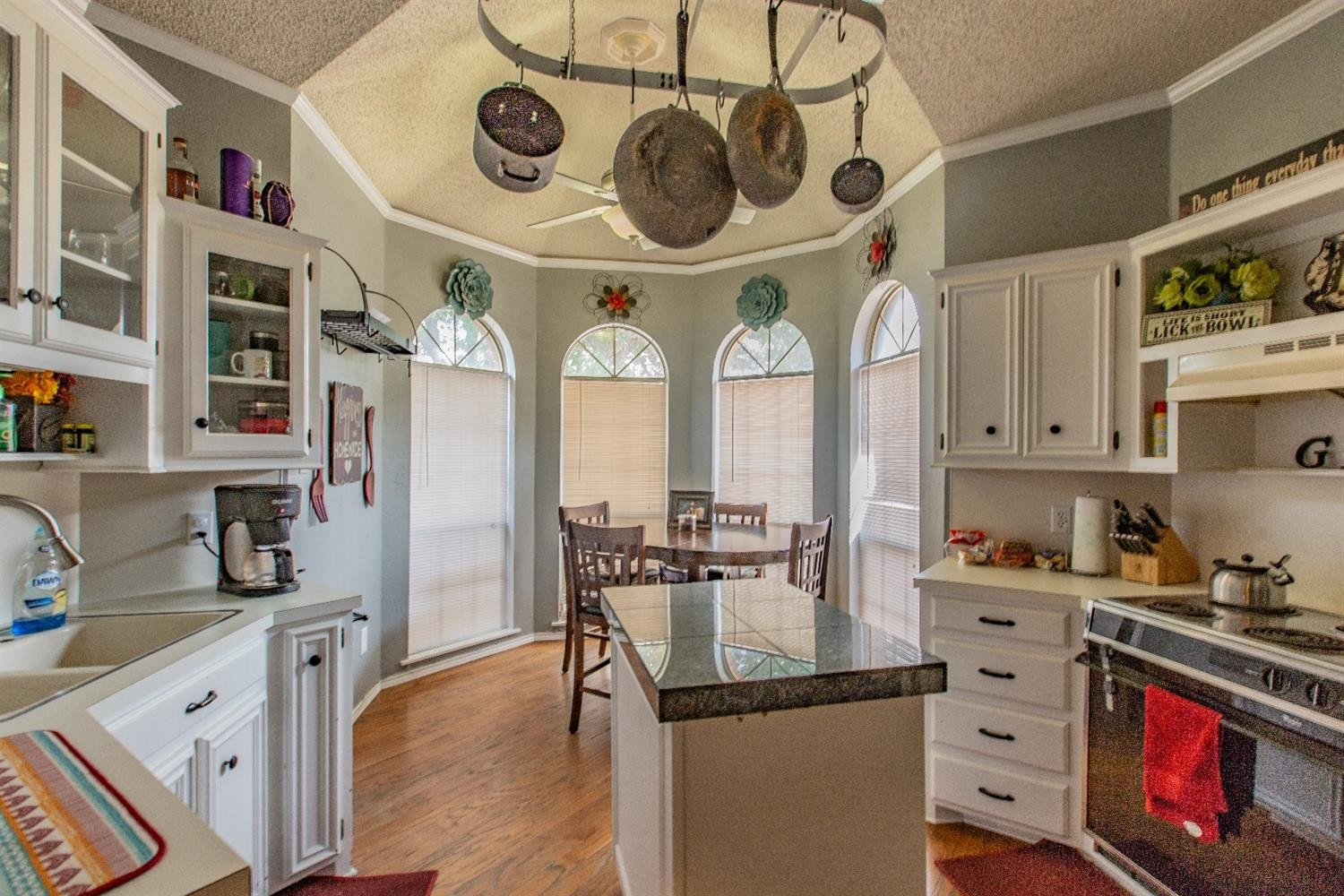 5738 94th Street Lubbock, TX 79424 - Photo 4 of 10 a kitchen with stainless steel appliances granite countertop a stove and a sink with cabinets