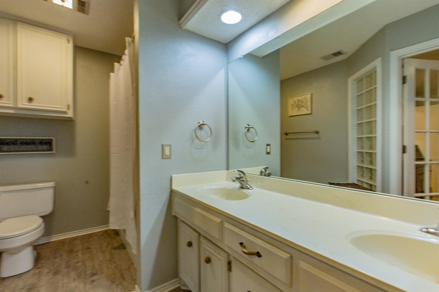 5738 94th Street Lubbock, TX 79424 - Photo 10 of 10 a bathroom with a sink and a large mirror