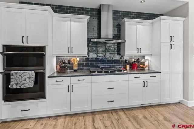 a kitchen with white cabinets and sink