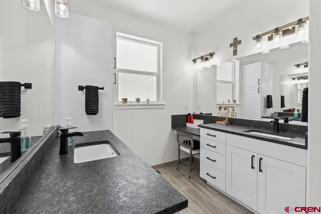 a kitchen with a sink dishwasher stove and white cabinets