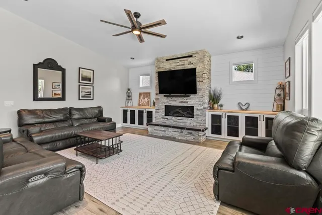 a living room with furniture a flat screen tv and a fireplace