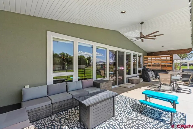 a living room with furniture a rug and a large window
