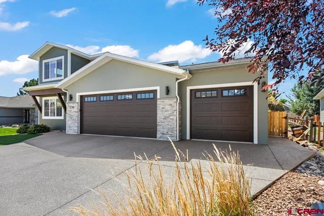 a front view of a house with a garage and a yard