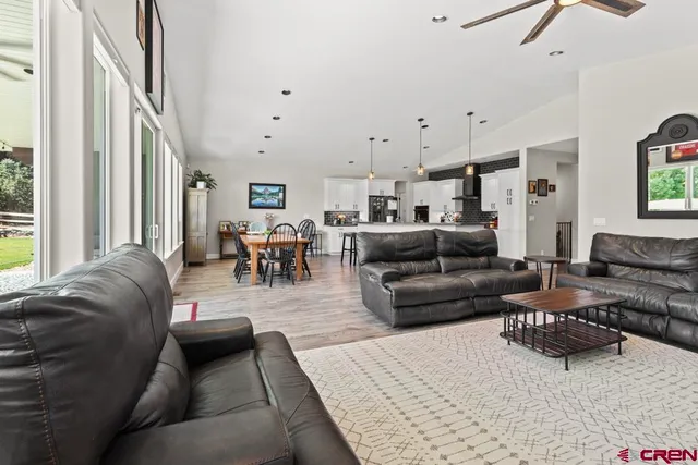 a living room with furniture kitchen view and a large window