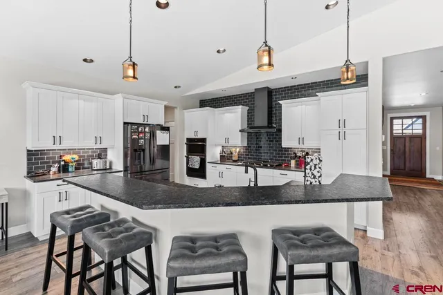 a kitchen with granite countertop a counter space cabinets stainless steel appliances and a wooden floor