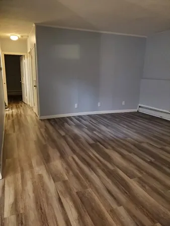 a view of an empty room with wooden floor