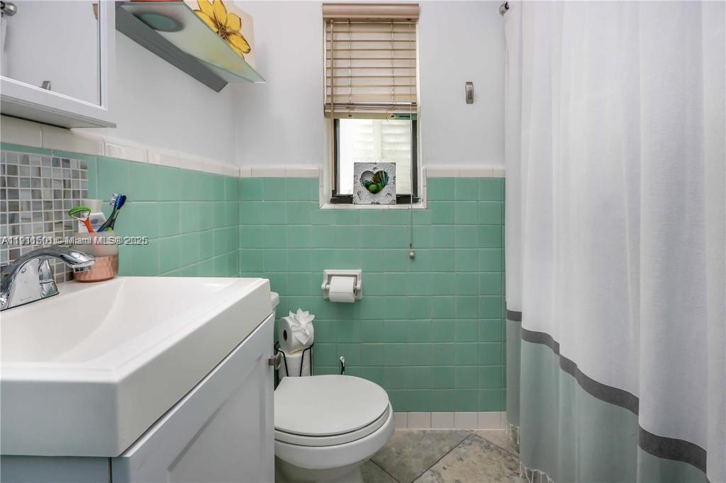 1516 Funston Street Hollywood, FL 33020 - Photo 17 of 23 a bathroom with a sink a toilet and mirror