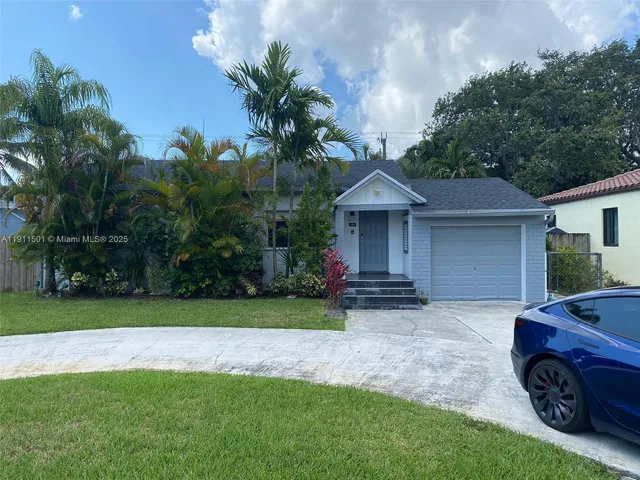 a front view of a house with a garden and trees