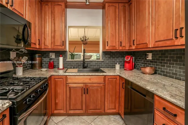 a kitchen with stainless steel appliances granite countertop a sink stove and cabinets