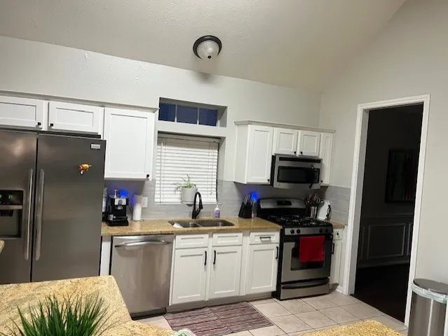 a kitchen with a refrigerator and a stove top oven