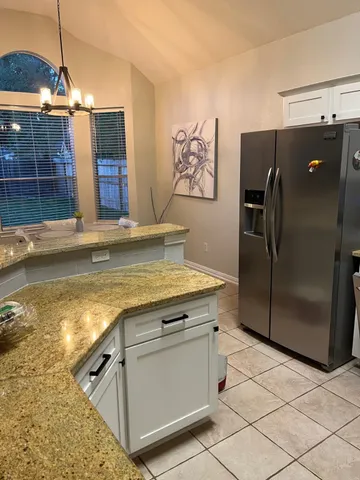 a kitchen with stainless steel appliances granite countertop a refrigerator and a sink