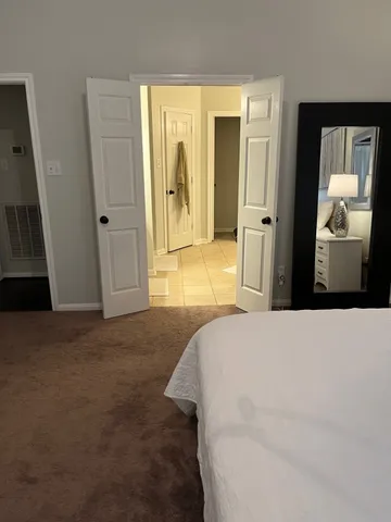 a bedroom with a bed and a large mirror