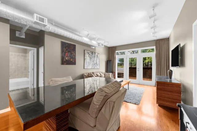 a living room with furniture large window and flat screen tv