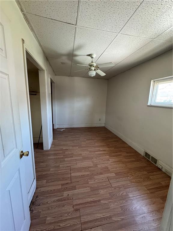 110 13th Street Conway, PA 15027 - Photo 4 of 6 an empty room with wooden floor and hallway