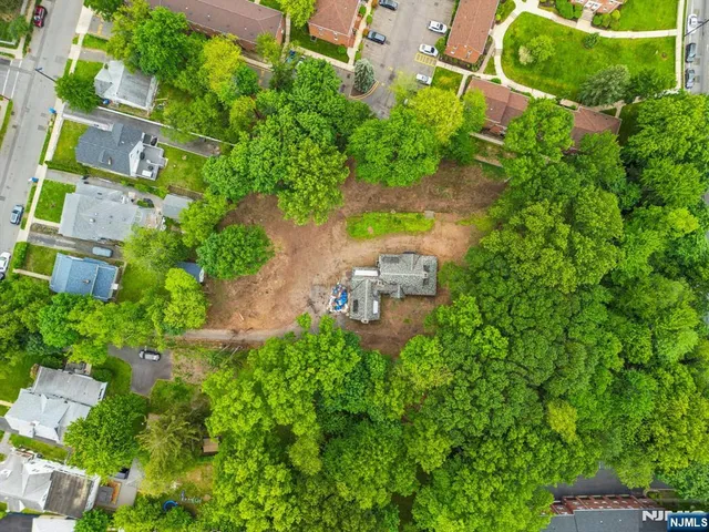 an aerial view of residential house with outdoor space and trees all around