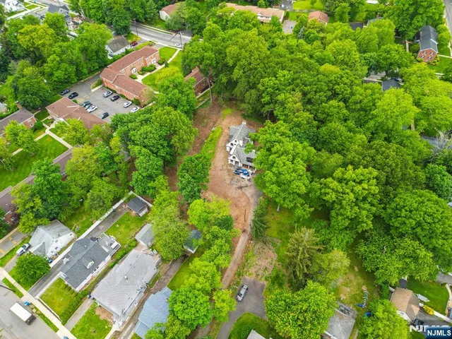 an aerial view of residential house with outdoor space and trees all around