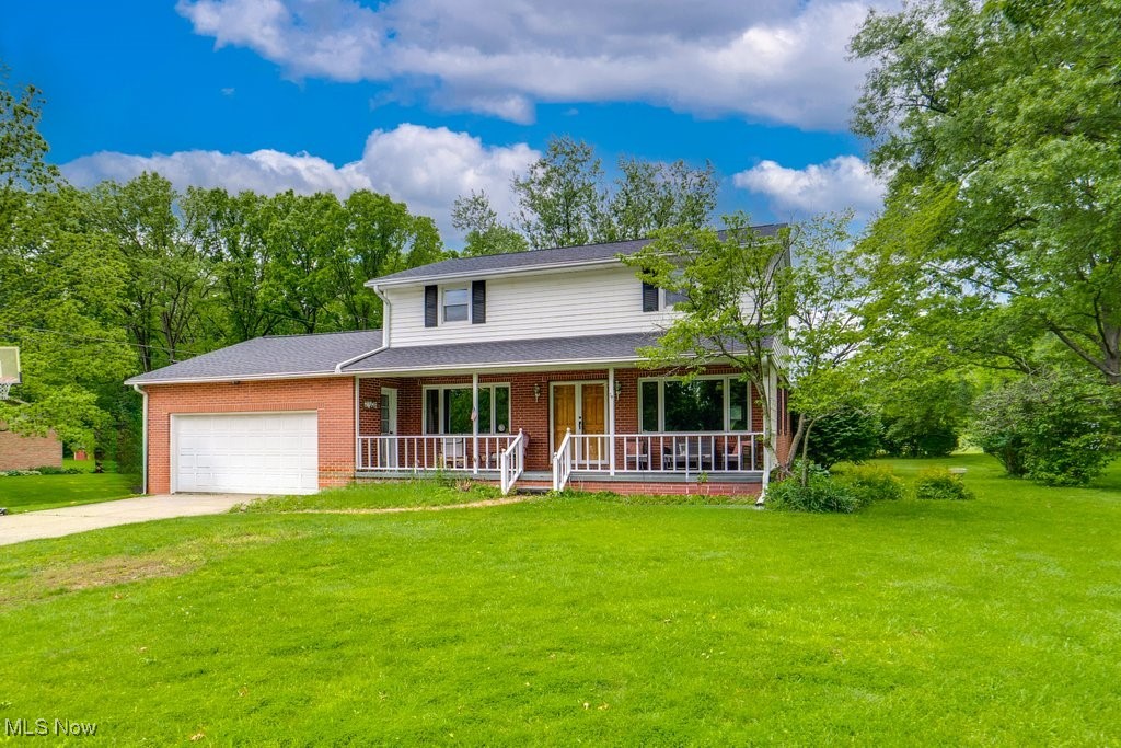 5867 Wiclif Road Northeast Canton, OH 44721 - Photo 1 of 45 Traditional-style house with a porch, an attached garage, a front lawn, and brick siding