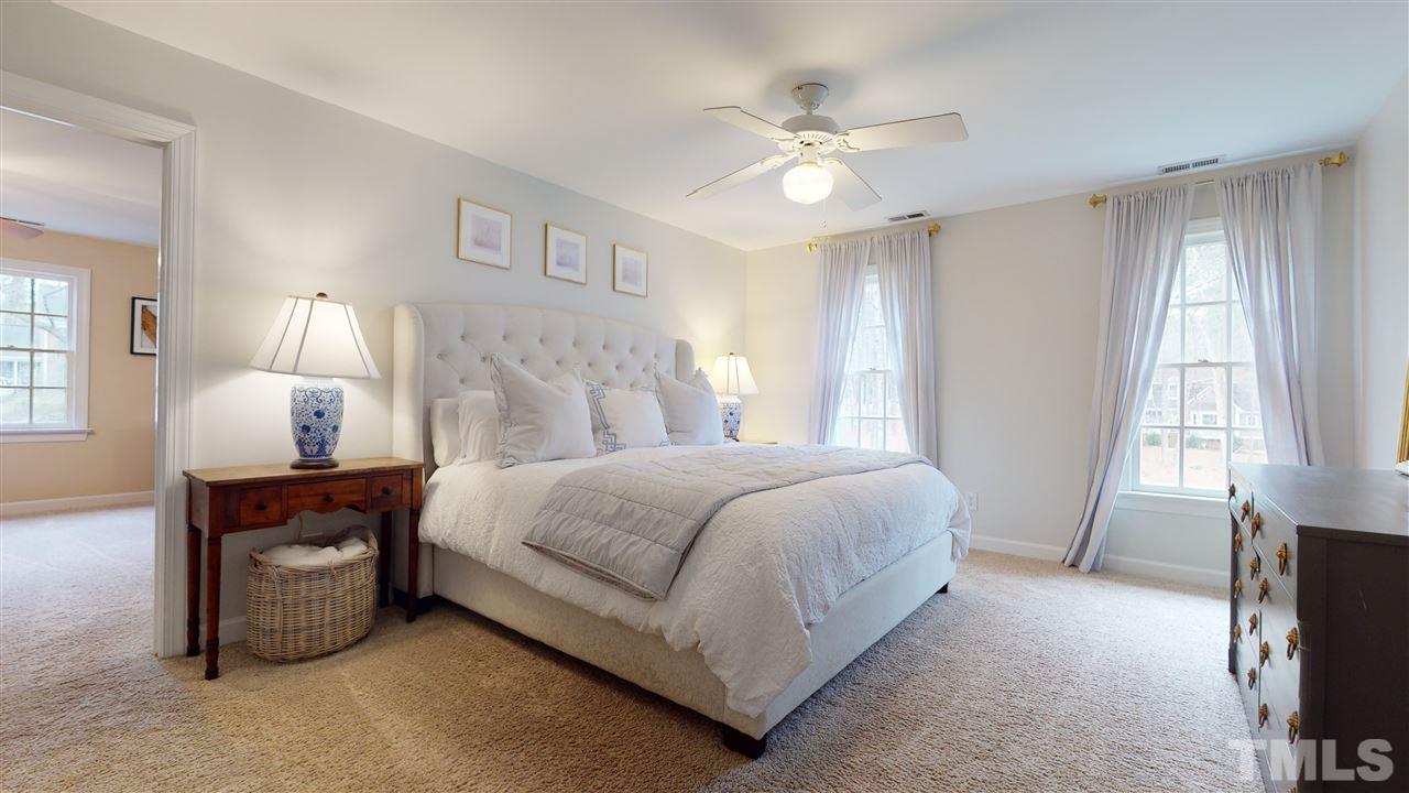 8101 Calais Court Raleigh, NC 27613 - Photo 17 of 24 a bedroom with a bed and a chandelier