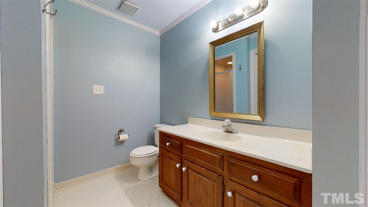 8101 Calais Court Raleigh, NC 27613 - Photo 18 of 24 a bathroom with a sink a toilet and a mirror