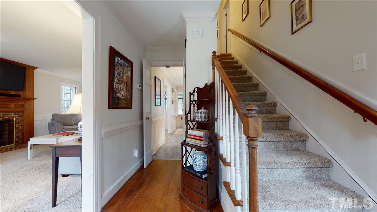 8101 Calais Court Raleigh, NC 27613 - Photo 4 of 24 a view of hallway with wooden floor and stairs