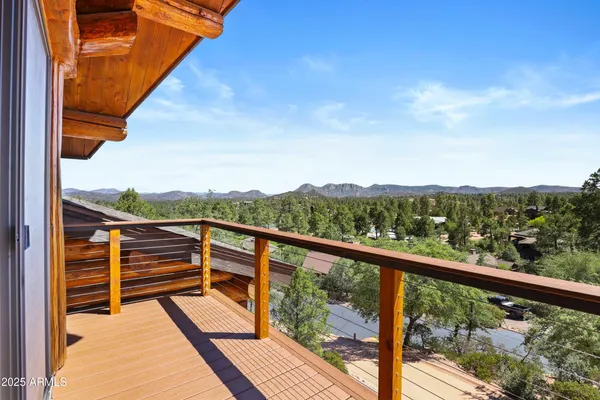 a view of a balcony with mountain view and wooden floor