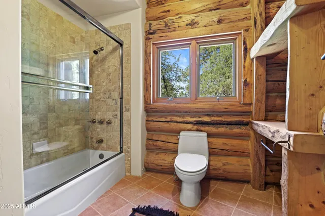 a living room with furniture a flat screen tv and a floor to ceiling window