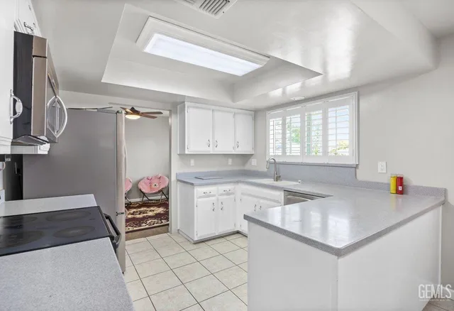 a kitchen that has a sink cabinets counter space and appliances