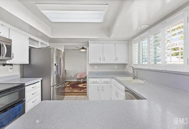 a kitchen that has a lot of cabinets in it and wooden floors