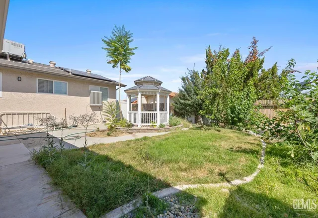 a view of a house with backyard and sitting area