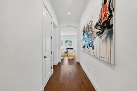 a view of a hallway with wooden floor and entryway