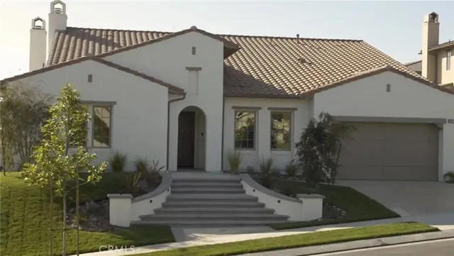 a front view of a house with plants